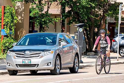 NIC ADAM / FREE PRESS
A cyclist rides past parked cars on St. Mary Ave., near Donald St., Wednesday.
240717 - Wednesday, July 17, 2024.

Reporter: Joyanne