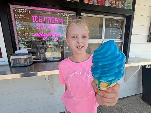 Nine-year-old Olivia from the Kemnay area, who joined her father out on the golf course on a Wednesday morning, holds a vanilla blue raspberry dip soft serve cone from Joe Dandy's Drive-In at Oak Lake. (Matt Goerzen/The Brandon Sun)