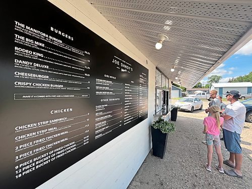 A large and detailed restaurant menu for Joe Dandy's Drive-In is on display outside the restaurant while ustomers line up outside the window for lunch on July 17. (Matt Goerzen/The Brandon Sun)