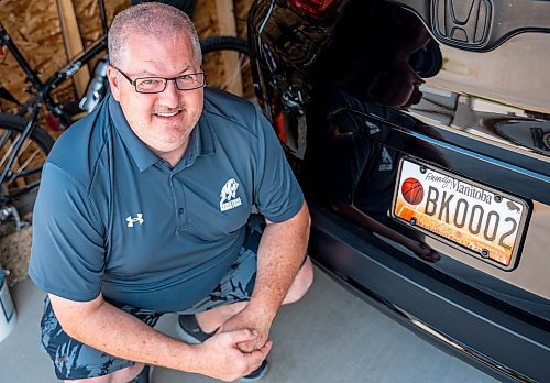 NIC ADAM / FREE PRESS
Adam Wedlake, Executive Director of Basketball Manitoba, pictured next to his basketball licence plate Thursday afternoon. His is the second the province ever made.
240718 - Thursday, July 18, 2024.

Reporter: Jura