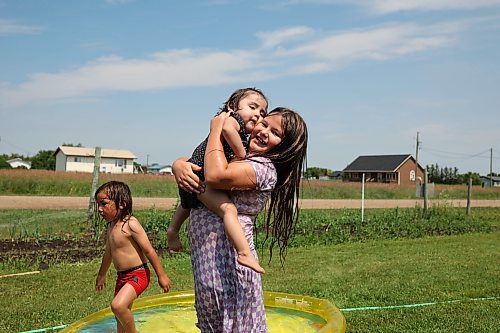 18072024
Leilani Taylor holds her sister Ivy Giesbrecht while playing in a wading pool with their brother Ruben Giesbrecht at their home at Sioux Valley Dakota Nation on a hot Thursday afternoon. 
(Tim Smith/The Brandon Sun)