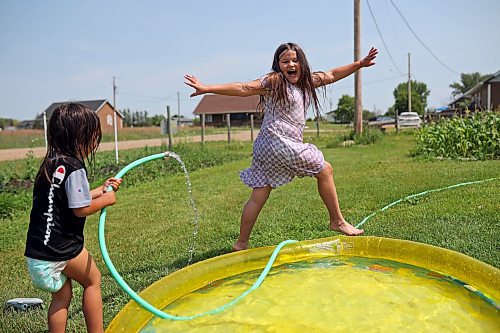 18072024
Ruben Giesbrecht and Leilani Taylorplay in the cool water in a wading pool in front of their home at Sioux Valley Dakota Nation on a hot Thursday afternoon. 
(Tim Smith/The Brandon Sun)