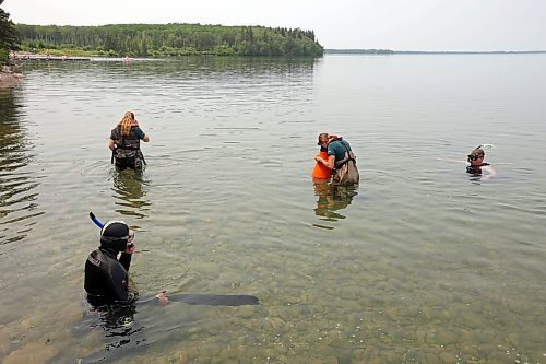 Parks Canada employees conduct visual inspections for signs of zebra mussels near Clear Lake's main boat cove in Riding Mountain National Park on Friday. Parks Canada announced Friday that they had found evidence of localized zebra mussel infiltration at Boat Cove. (Tim Smith/The Brandon Sun)
