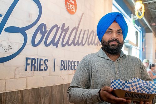 BROOK JONES / FREE PRESS
Boardwalk Fries Burgers Shakes at the Park West Shopping Centre located at 6650 Roblin Blvd. in Winnipeg, Man., celebrates its grand opening Friday, July 19, 2024. Franchisee Garry Cheema, 33, is pictured holding a burger during the celebration.