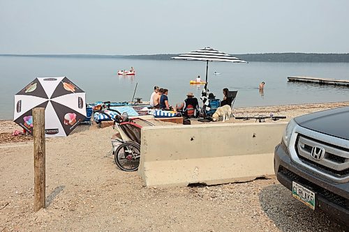 19072024
Beach goers enjoy the hot weather and cool water at the Clear Lake boat cove in Riding Mountain National Park on Friday as wooden poles and concrete barriers prevent boat launches into the lake. Parks Canada announced Friday that they had found evidence of localized zebra mussel infiltration at the boat cove. 
(Tim Smith/The Brandon Sun)
