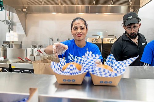 BROOK JONES / FREE PRESS
Boardwalk Fries Burgers Shakes at the Park West Shopping Centre located at 6650 Roblin Blvd. in Winnipeg, Man., is celebrating its grand opening Friday, July 19, 2024. Happy Cheema, who is the wife of owner Garry Cheema, is pictured placing two cheeseburger orders in the pass area during the celebration. 