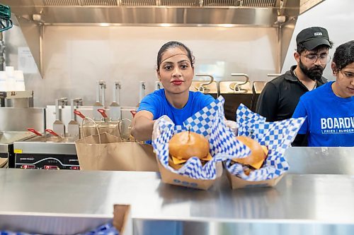 BROOK JONES / FREE PRESS
Boardwalk Fries Burgers Shakes at the Park West Shopping Centre located at 6650 Roblin Blvd. in Winnipeg, Man., is celebrating its grand opening Friday, July 19, 2024. Happy Cheema, who is the wife of owner Garry Cheema, is pictured placing two cheeseburger orders in the pass area during the celebration. 