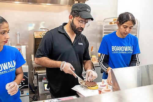 BROOK JONES / FREE PRESS
Boardwalk Fries Burgers Shakes at the Park West Shopping Centre located at 6650 Roblin Blvd. in Winnipeg, Man., is celebrating its grand opening Friday, July 19, 2024. Morning manager Parchem Saini (middle) is pictured placing a beef patty on a hamburger bun.