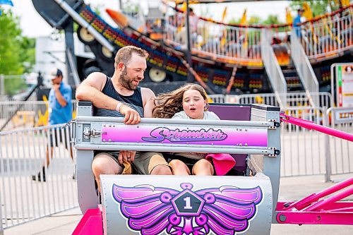 NIC ADAM / FREE PRESS
Dani (left) and his daughter Quinn enjoy a midway ride at the Manitoba Stampede &amp; Exhibition Friday afternoon.
240719 - Friday, July 19, 2024.

Reporter: Jura