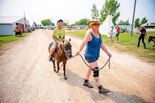 NIC ADAM / FREE PRESS
Naleen Kitson (right) gives a miniature pony ride to Steven Fang at the Manitoba Stampede &amp; Exhibition Friday afternoon.
240719 - Friday, July 19, 2024.

Reporter: Jura