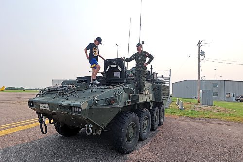 Cpl. Jordan Oakley from 2PPCLI helps 13-year-old Graydon Gosseye climb into the cockpit of a LAV 6 infantry fighting vehicle at the Brandon Flight Centre's fly-in breakfast on Saturday morning. (Colin Slark/The Brandon Sun)