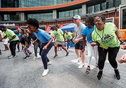 JOHN WOODS / FREE PRESS
Provincial minister Uzoma Asagwara and mayor Scott Gillingham dance with members of Pegcity Steppers at their Health And Wellness Day event at True North Square Sunday, July 21, 2024. 

Reporter: