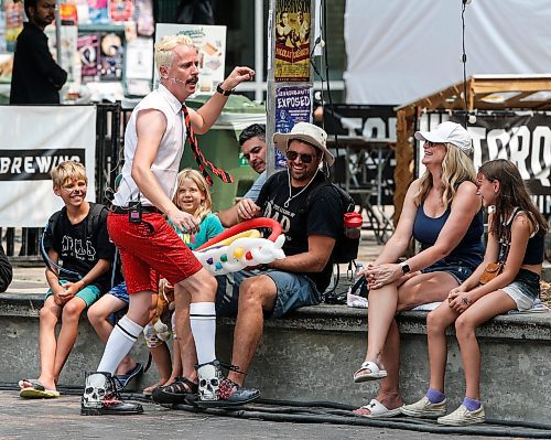 JOHN WOODS / FREE PRESS
Spencer Brason, centre, looks on as Wham Glam Circus Man performs at the Fringe in Old Market Square Sunday, July 21, 2024. 

Reporter: