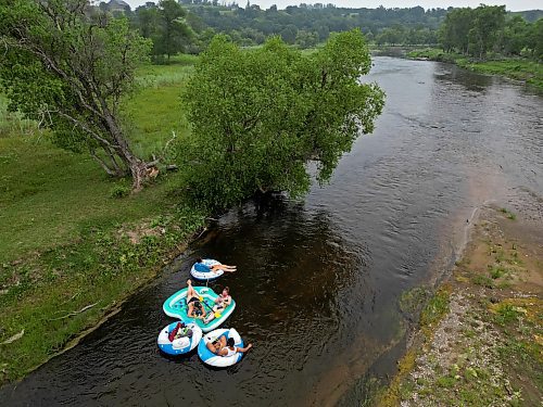 A precariously rooted tree on the riverbank provides a little bit of shade for the floaters. (Tim Smith/The Brandon Sun)