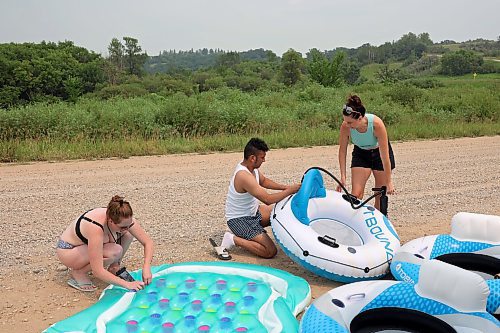 22072024
Jodie Tocher, Luis Alvarenga and Loren Lobreau inflate tubes at Kirkham Bridge west of Brandon for rafting down the Little Saskatchewan River with friends on a hot and humid Monday afternoon. 
(Tim Smith/The Brandon Sun)