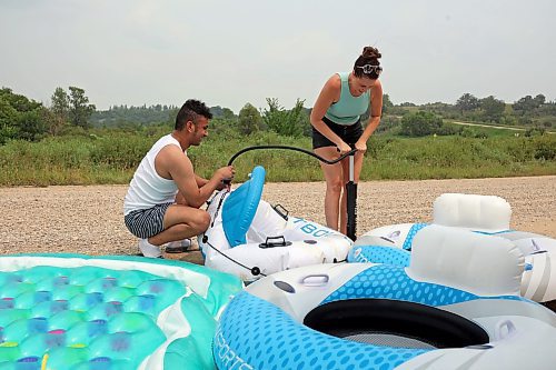 22072024
Luis Alvarenga and Loren Lobreau inflate tubes at Kirkham Bridge west of Brandon for rafting down the Little Saskatchewan River with friends on a hot and humid Monday afternoon. 
(Tim Smith/The Brandon Sun)