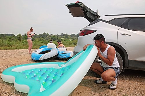 22072024
Friends Jodie Tocher, Loren Lobreau, Cassandra Kowalchuk and Luis Alvarenga inflate rafts at Kirkham Bridge west of Brandon for floating down the Little Saskatchewan River on a hot and humid Monday afternoon. 
(Tim Smith/The Brandon Sun)