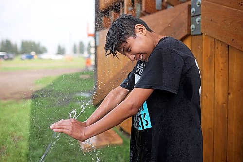 Dorian Blacksmith cools off in the spray from a sprinkler. (Tim Smith/The Brandon Sun)
