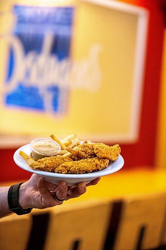 MIKAELA MACKENZIE / FREE PRESS

Andrew Van Seggelen, co-owner of Bodegoes, with a plate of their chicken fingers on Tuesday, July 23, 2024. 

For Dave Sanderson story.