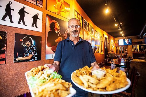 MIKAELA MACKENZIE / FREE PRESS

Owner Johnny Giannakis holds plates of chicken fingers at Johnny G's on Tuesday, July 23, 2024. 

For Dave Sanderson story.