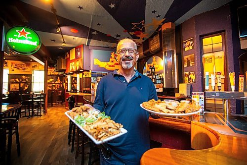 MIKAELA MACKENZIE / FREE PRESS

Owner Johnny Giannakis with plates of chicken fingers at Johnny G's on Tuesday, July 23, 2024. 

For Dave Sanderson story.