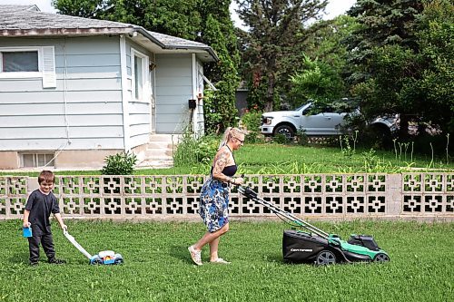 24072024
Five-year-old Owen Poitras follows along with his own toy lawnmower as his mom Marla Poitras mows the lawn at their home in Brandon on a hot Wednesday.
(Tim Smith/The Brandon Sun)