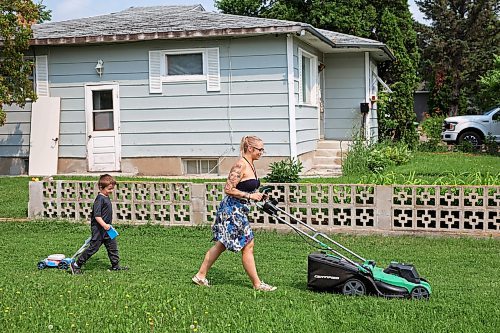 24072024
Five-year-old Owen Poitras follows along with his own toy lawnmower as his mom Marla Poitras mows the lawn at their home in Brandon on a hot Wednesday.
(Tim Smith/The Brandon Sun)