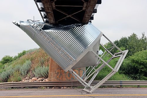 A grain bin carried by a Heritage Co-op truck sits wedged under a rail overpass on Highway 10, just north of Forrest, after a truck carrying it tried to pass underneath the bridge. (Colin Slark/The Brandon Sun)