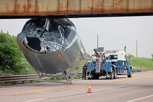 A tow truck from Full Tilt Towing frees a grain bin wedged under a rail overpass just north of Forrest in the RM of Elton on Thursday afternoon. (Colin Slark/The Brandon Sun)