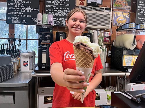 A staff member at The Chocolate Fox in Wasagaming holds up a medium cone with two flavours of gelati —lime and chocolate — for $7. The store also carries various specialty coffees, including cappuccino and lattes. (Photos by Matt Goerzen/The Brandon Sun)