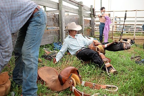 Cache Schellenberg of Melfort, Sask., stretches and adjusts his saddle before competing in the saddle bronc event. (Tim Smith/The Brandon Sun)