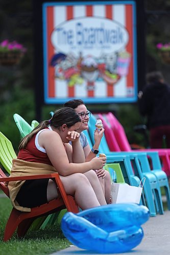 A pair of friends eat ice cream cones outside The Boardwalk on Clear Lake in the community of Wasagaming at Riding Mountain National Park on a warm but overcast Tuesday afternoon. (Matt Goerzen/The Brandon Sun)