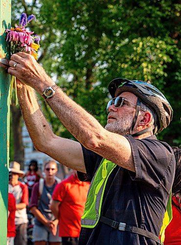 NIC ADAM / FREE PRESS
Hundreds of winnipeggers left flowers at the memorial  ghost bike honouring the life of cyclist Rob Jenner, who lost his life to a hit-and-run driver on Wellington Crescent at Cockburn Street, pictured Thursday afternoon.
240725 - Thursday, July 25, 2024.

Reporter: Jura