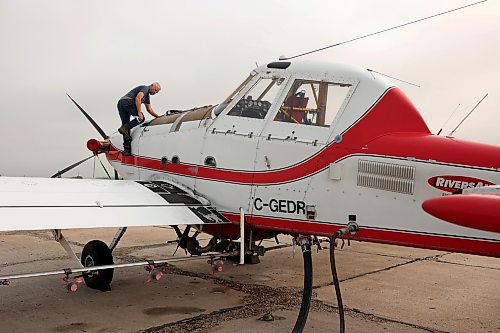 John Lepp with Rivers Air Spray climbs on his Air Tractor AT-802F to clean the windshield on Thursday morning while preparing for a day of fungicide application to crops in Westman. (Tim Smith/The Brandon Sun)