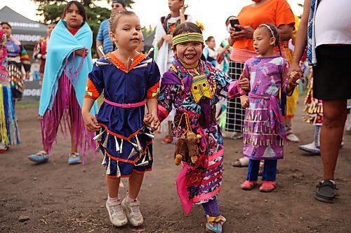 Miika Campbell, 4, and Azrielle Patricio, 3, dance together while waiting to take part in the Grand Entry. (Tim Smith/The Brandon Sun)