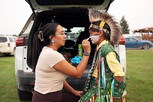 Brody Nepinak of Dauphin has his face paint done by his mother Carey while getting ready to compete in the traditional dance category. (Tim Smith/The Brandon Sun)