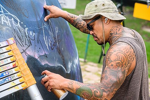 Mike Sudoma/Free Press
Artist Pat Lazo cleans up a plethera of graffiti tags on the mural of Sk8 Skates founder Jai Pereira at the bowl at the Forks Plaza Friday morning
July 26, 2024
