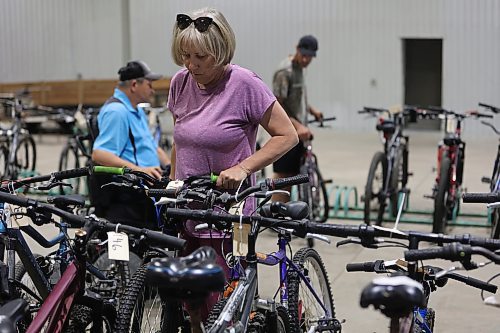 Barb Simon checks the height and handlebars on a bike that was up for auction during the Kiwanis Club of Brandon's bike auction on Saturday, held in the Manitoba Room at the Keystone Centre. (Michele McDougall/The Brandon Sun) 