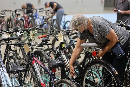 A woman inspects a bicycle made in the United Kingdom that was up for auction during the Kiwanis Club of Brandon's bike auction on Saturday, held in the Manitoba Room at the Keystone Centre. (Michele McDougall/The Brandon Sun) 