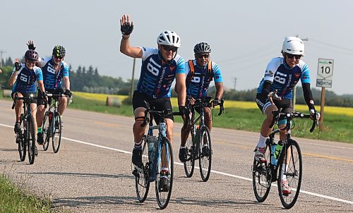 Winnipeg's Kevin Donnelly waves while riding beside David Ranta (right) and Tim Hague (middle). Liliane Kirouac Vilar (far left) and Richard Cloutier are close behind. They and nine others are cycling 504 kilometres from Russell to Falcon Lake to raise awareness and money for the charity U-Turn Parkinson's, which provides free exercise programs for people living with Parkinson's disease. (Michele McDougall/The Brandon Sun) 