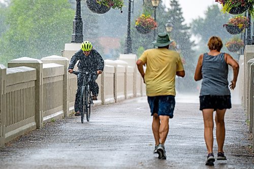 NIC ADAM / FREE PRESS
Cyclist Jen Bailey gets caught in a storm while riding her bike into Assiniboine Park Monday afternoon.
240729 - Monday, July 29, 2024.

Reporter:?