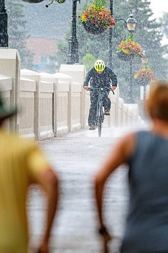 NIC ADAM / FREE PRESS
Cyclist Jen Bailey gets caught in a storm while riding her bike into Assiniboine Park Monday afternoon.
240729 - Monday, July 29, 2024.

Reporter:?