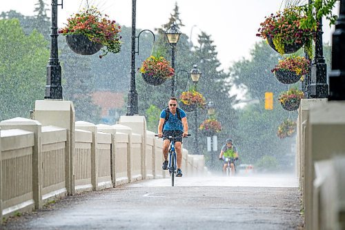 NIC ADAM / FREE PRESS
Cyclists at Assiniboine park get caught in the storm Monday afternoon.
240729 - Monday, July 29, 2024.

Reporter:?