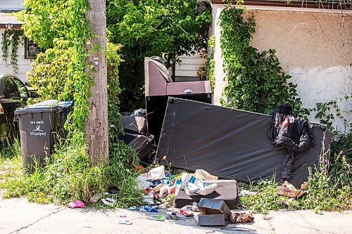 MIKAELA MACKENZIE / FREE PRESS

	
Garbage and furniture behind the scene of a recent fire at a vacant, boarded-up bungalow on Burrows Avenue on Tuesday, July 30, 2024. 

For Nicole story.