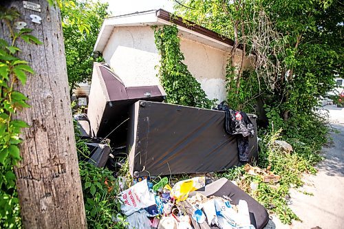 MIKAELA MACKENZIE / FREE PRESS

	
Garbage and furniture behind the scene of a recent fire at a vacant, boarded-up bungalow on Burrows Avenue on Tuesday, July 30, 2024. 

For Nicole story.