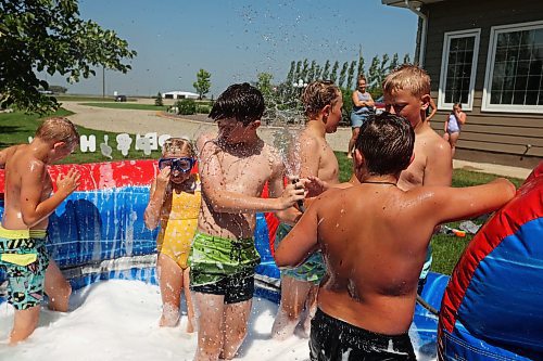 30072024
Kids play in water and soap bubbles on a large inflatable slide during a birthday party for Kord Anderson, twelve, at the Anderson&#x2019;s home east of Souris on a hot Tuesday. (Tim Smith/The Brandon Sun)