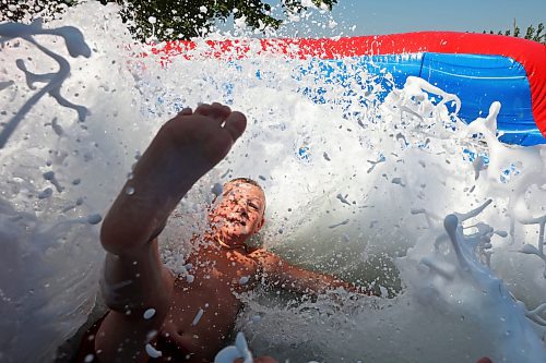 30072024
Dierk Anderson kicks up a big splash of foamy water while beating the heat on Tuesday on a large inflatable slide at the Anderson&#x2019;s home east of Souris during a birthday party for Kord Anderson, who turns twelve today. (Tim Smith/The Brandon Sun)