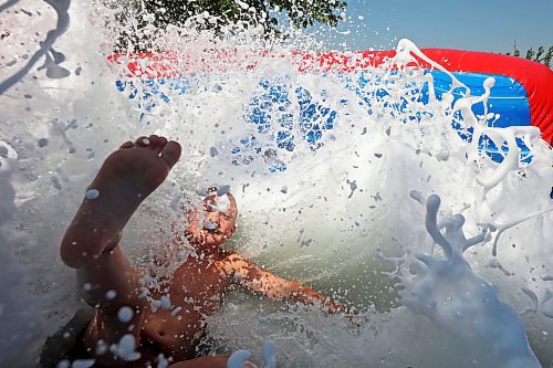 30072024
Dierk Anderson kicks up a big splash of foamy water while beating the heat on Tuesday on a large inflatable slide at the Anderson&#x2019;s home east of Souris during a birthday party for Kord Anderson, who turns twelve today. (Tim Smith/The Brandon Sun)