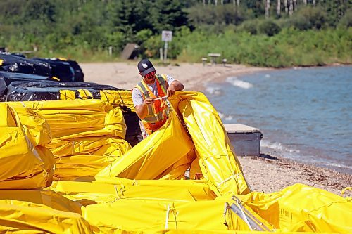 31072024
Workers with ASI Group unpackage and link silt curtains at the Clear Lake boat cove in Riding Mountain National Park on Wednesday. The silt curtains are being set up in Clear Lake from boat cove to the pier as part of extensive work by Parks Canada in the wake of limited zebra mussel activity being found in the lake. 
(Tim Smith/The Brandon Sun)