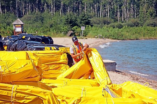 31072024
Workers with ASI Group unpackage and link silt curtains at the Clear Lake boat cove in Riding Mountain National Park on Wednesday. The silt curtains are being set up in Clear Lake from boat cove to the pier as part of extensive work by Parks Canada in the wake of limited zebra mussel activity being found in the lake. 
(Tim Smith/The Brandon Sun)